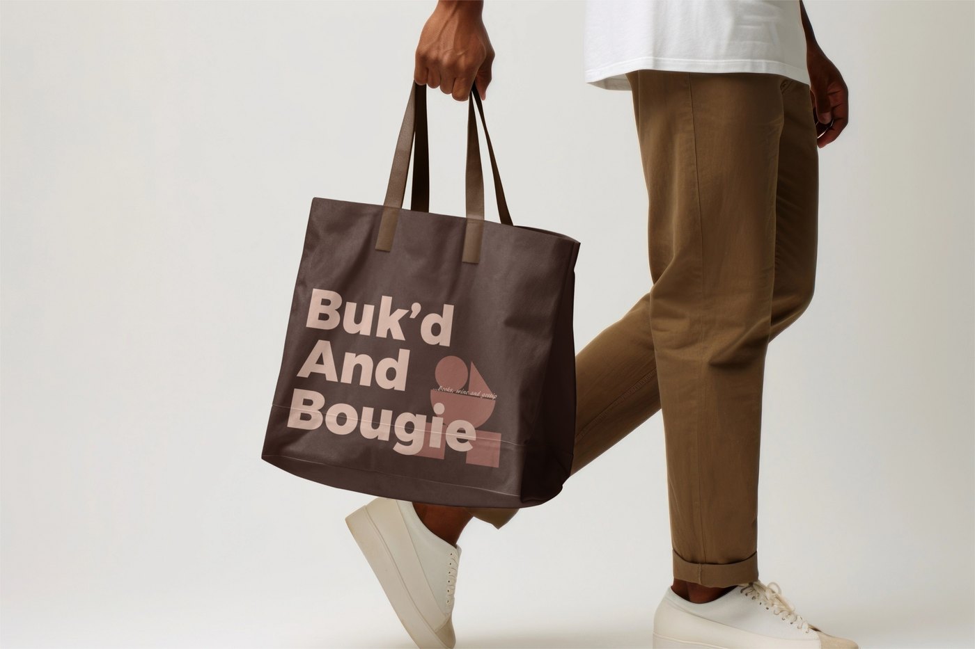 A Buk'd and Bougie tote bag carried over one shoulder